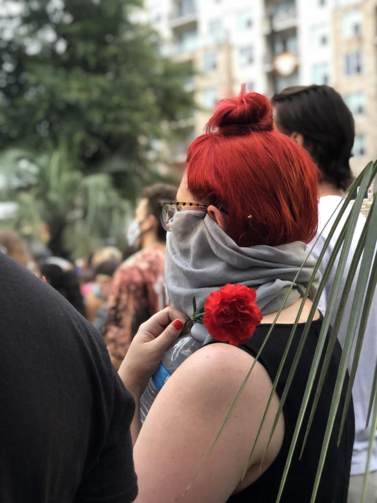 A woman holds a rose at the vigil Tuesday night.